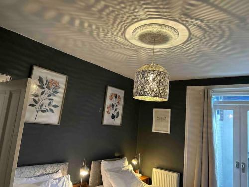 a bedroom with a chandelier hanging from a ceiling at London 2 Bedrooms with Private Garden Apartment Walking Distance to Underground Ideal for Families in London