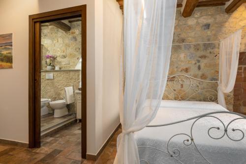 a bedroom with a bed and a bathroom at Sognare nel Castello in Monteriggioni