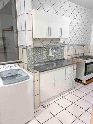 Il comprend une cuisine équipée d'un évier et d'un lave-linge. dans l'établissement Apartamento próximo da Praia, à Vila Velha