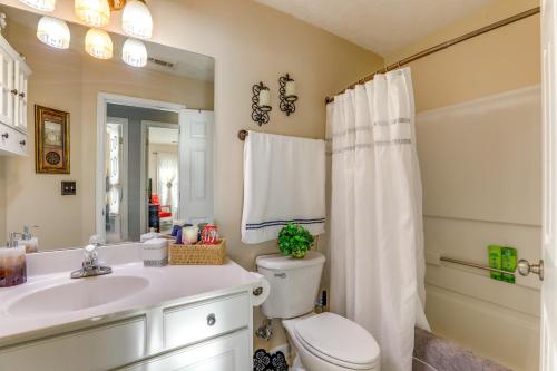 a bathroom with a toilet and a sink and a mirror at Cozy Buford Home with Piano about Mins to Lake Lanier! in Buford