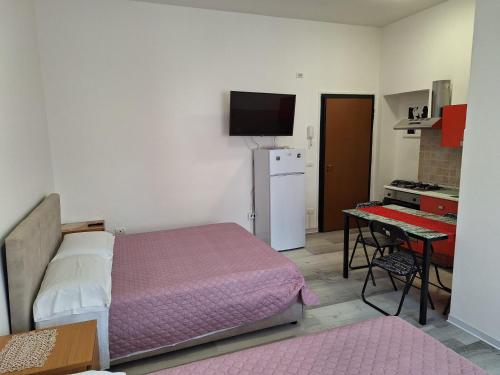 a small bedroom with a bed and a desk with a computer at Giada Rooms in Peschiera del Garda