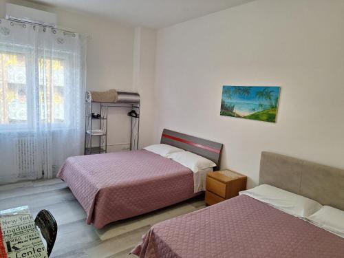 a hotel room with two beds and a window at Giada Rooms in Peschiera del Garda