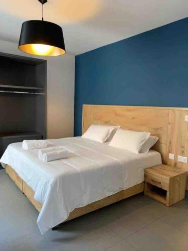 ein Schlafzimmer mit einem großen Bett und einer blauen Wand in der Unterkunft Village point Sliema 2 bedroom in Sliema
