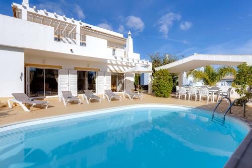 a villa with a swimming pool in front of a house at Casa Julia - V029 in Lagos