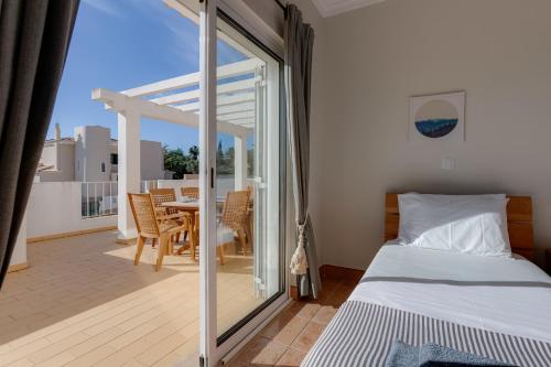 a bedroom with a bed and a balcony with a table at Casa Julia - V029 in Lagos