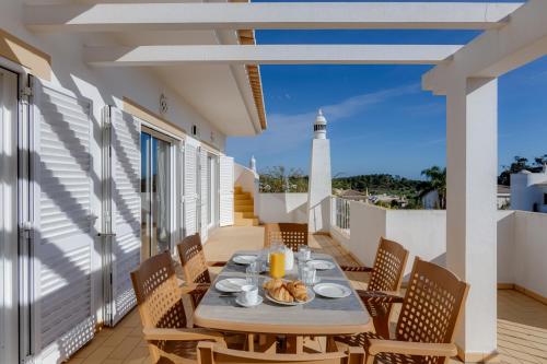 a table and chairs on a balcony with a lighthouse at Casa Julia - V029 in Lagos