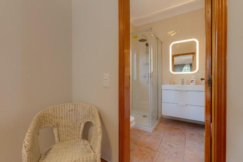 a bathroom with a wicker chair and a sink at Casa Julia - V029 in Lagos