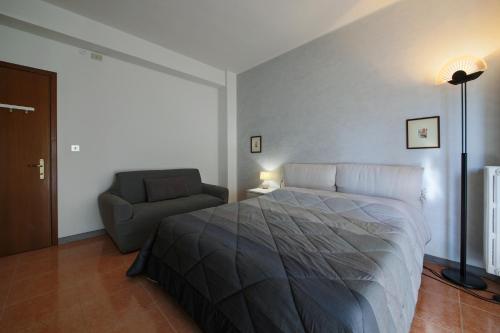 a bedroom with a bed and a chair in it at Private parking - Family home - 15 min to Venice in Mestre