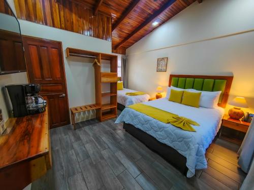 1 dormitorio con 1 cama y TV. en Sibu Lodge, en Monteverde
