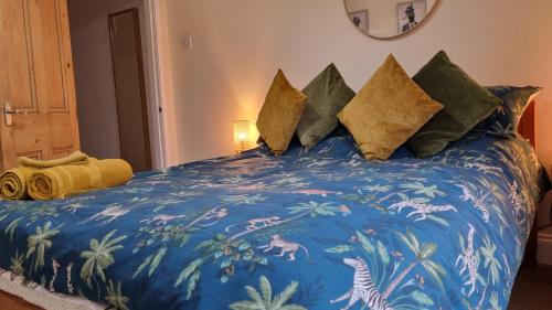 a bed with a blue comforter and pillows at City Of Chester Award Winning Cottage -Pixie Terrace Chester in Chester