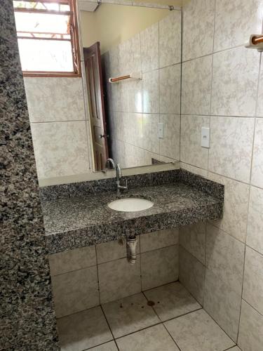 a bathroom with a sink and a mirror at Refúgio Aconchegante e Espaçoso in Araguaína