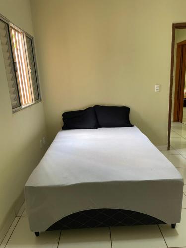 a bed in a small room with a white mattress at Refúgio Aconchegante e Espaçoso in Araguaína
