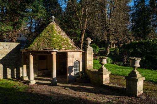 a small house with a roof and a yard at The Hall - Historic Grade I-listed Jacobean Mansion in Bradford on Avon