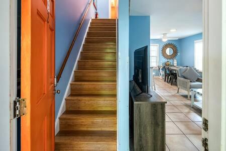 a hallway with a staircase with a television and a living room at Road's End in Key West