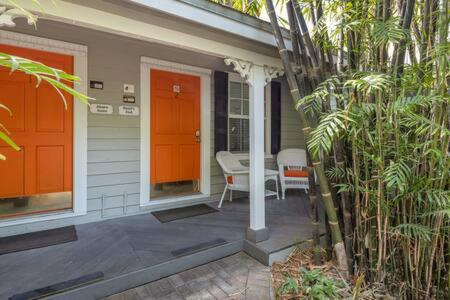 a porch of a house with an orange door at Road's End in Key West