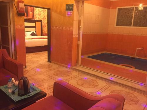 uma casa de banho com uma banheira com luzes roxas no chão em هوتيل المجاردة em Al Majaridah