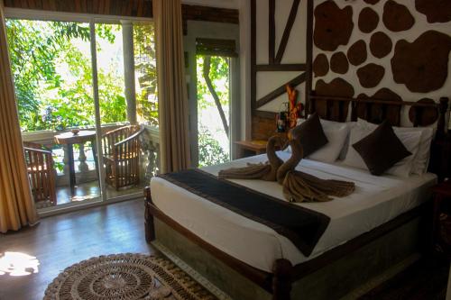 a bedroom with a bed in a room with a balcony at Villa Olde Ceylon in Kandy