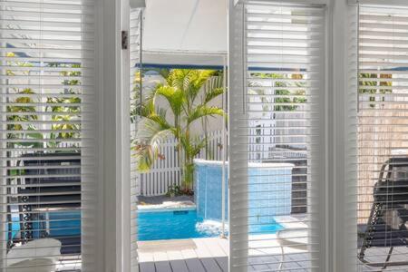 uma janela com vista para uma piscina e edifícios em Poolside Paradise by Brightwild em Key West