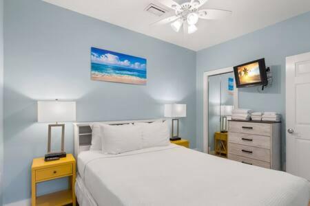 um quarto com uma cama branca e uma parede azul em Poolside Paradise by Brightwild em Key West