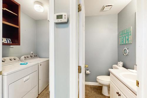 a white bathroom with a toilet and a sink at Panhandle Luxury D in Panama City Beach
