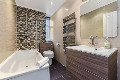 y baño con bañera, lavabo y aseo. en 1 Bed- Hyde Park- Central London, en Londres