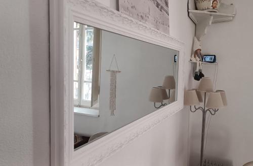 um espelho num quarto branco com uma janela em Antico Chalet Mini Momosa em Ovindoli