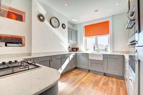 a kitchen with white cabinets and a stove top oven at Modern 4 Bedroom townhouse perfect location. in Brighton & Hove