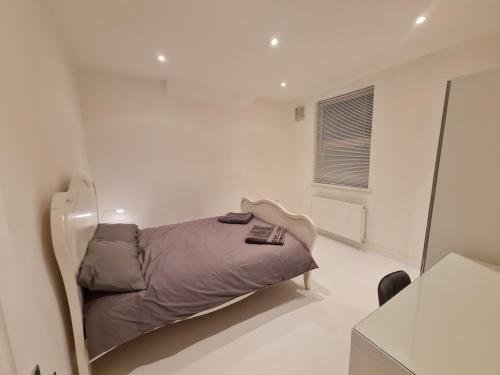 sypialnia z łóżkiem w białym pokoju w obiekcie Leyton Park Place w Londynie
