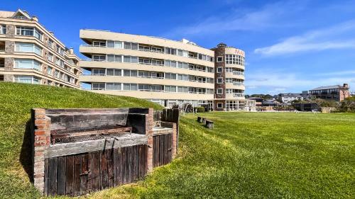 a building in front of a field with a fence at Marcin Hotel in Carilo