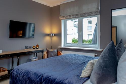 a bedroom with a blue bed and a window at Steuerbord in Westerland (Sylt)