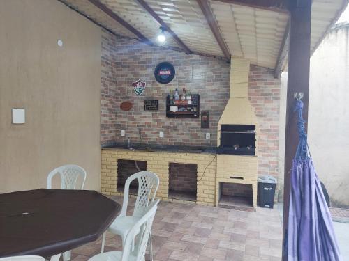 a brick wall with a table and chairs and a fireplace at Cabo frio Condomínio dos pássaros in Cabo Frio
