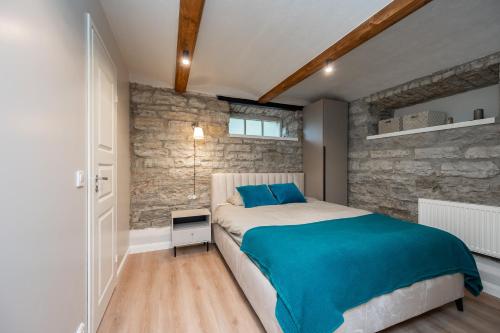 - une chambre avec un lit et un mur en pierre dans l'établissement Kalamaja Apartment, à Tallinn