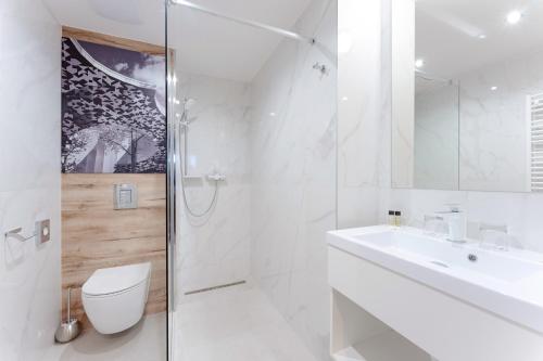 a white bathroom with a toilet and a sink at Onyx Luxury Budapest in Budapest