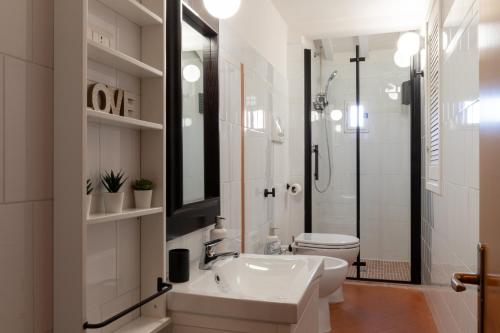 ein weißes Bad mit einem Waschbecken und einem WC in der Unterkunft La Casa di Emilia in Florenz