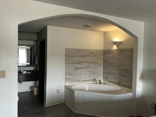 y baño con bañera y arco. en Days Inn by Wyndham Decatur Priceville I-65 Exit 334, en Decatur