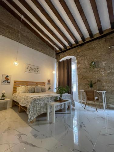 een slaapkamer met een bed en een tafel bij BF BOUTIQUE JEREZ in Jerez de la Frontera