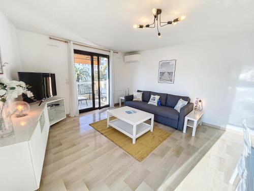un salon avec un canapé bleu et une table dans l'établissement Bright and vast 1BR balcony parking heart of town 1 mn, à Cannes