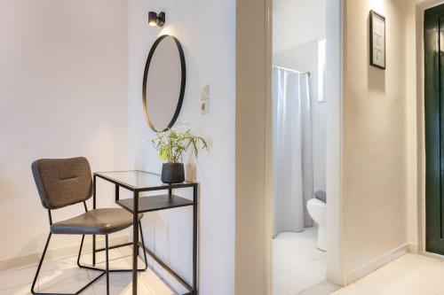 a bathroom with a mirror and a chair and a toilet at Ciel Comfort Living in Laganas
