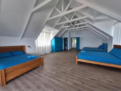 a large room with two beds and blue sheets at Paunch Beach Retreat in Bocas del Toro