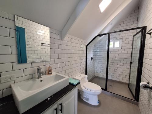 een witte badkamer met een wastafel en een toilet bij Paunch Beach Retreat in Bocas del Toro
