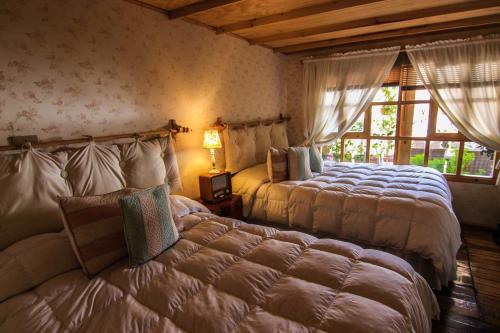 a bedroom with two beds and a window at Bamba House Cusco in Cusco
