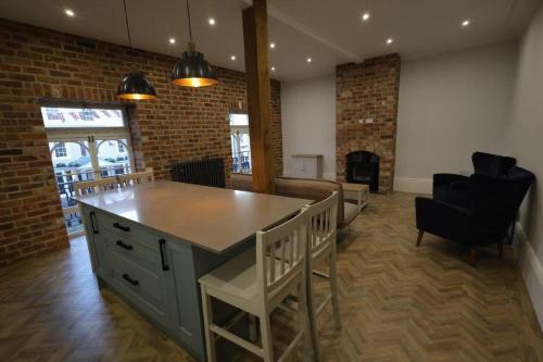 a room with a large island in a room with chairs at Red Lion Apartments in Spalding