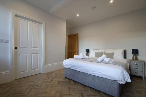 a bedroom with a large bed with white sheets at Red Lion Apartments in Spalding