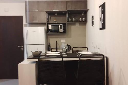 een keuken met een zwart aanrecht en een koelkast bij Comodidad y lujo! Con desayuno Incluido! G&A Rent in Ezeiza