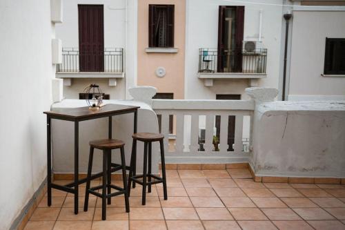 a small table and two stools on a balcony at Appartamento centrale vista mare Benny's apartment in Bari