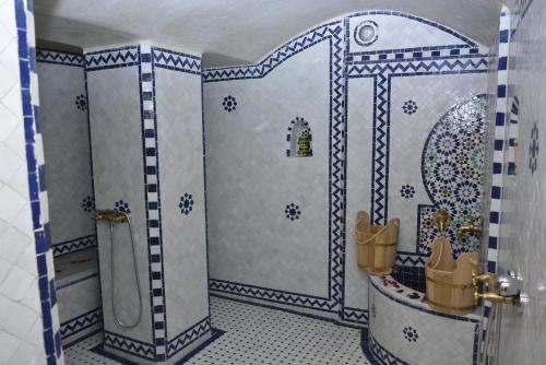 a bathroom with a shower with blue and white tiles at Riad Fes Colors & Spa in Fès