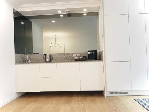 a bathroom with white cabinets and a large mirror at Tomy Old Town Apartments in Vilnius