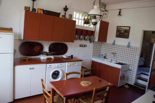 une cuisine avec une table et une machine à laver dans l'établissement Logis Vendéen 10-12 personnes. piscine et parc., à La Jaudonnière