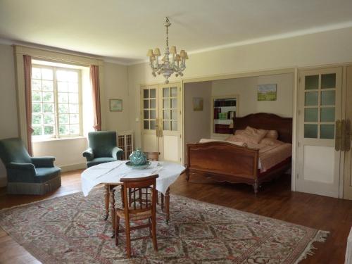 un salon avec une table et un lit dans l'établissement Logis Vendéen 10-12 personnes. piscine et parc., à La Jaudonnière