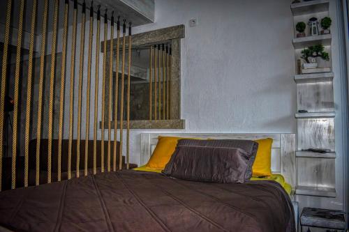 - une chambre avec un lit et un oreiller jaune dans l'établissement Terminal Vidikovac, à Budva